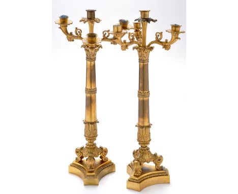 *A pair of Regency ormolu candlesticks, each with five sconces on scrolling arms and fluted stem, raised on acanthus capped c