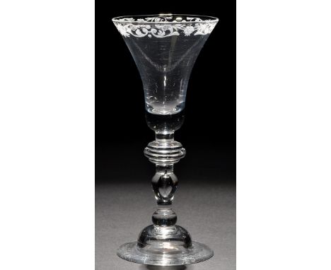 A light baluster goblet, the bell bowl engraved with a baroque scroll to the rim, raised on an annular knop above a teared ba