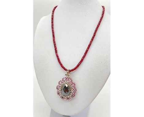 135cts of Ruby in a Pendant with Black Pear Moissanite. Surrounded by halo of diamonds in sterling silver and a 3mm single ro