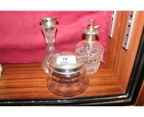 A silver top dressing table jar; a silver rimmed vase and a white metal an enamel mounted perfume atomiser