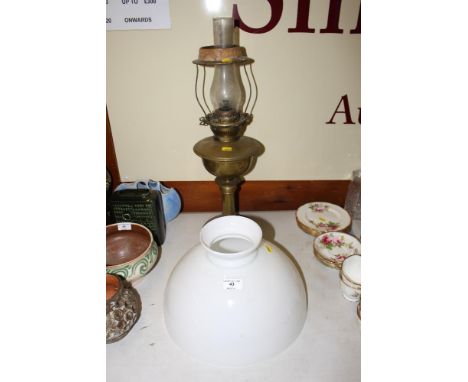 A brass oil lamp with glass shade