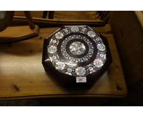 A red lacquered and mother of pearl inlaid octagonal box and cover