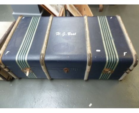 A vintage blue travel trunk with wood strapping