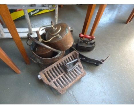 A  cast iron fire grate and fender with vent, with a coal scuttle, two copper kettles and two vintage irons, one decorated wi
