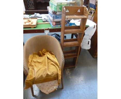 A narrow oak book shelf trefoil carved top over five shelves 31cmW with a Lloyd Loom gold sprayed wicker chair