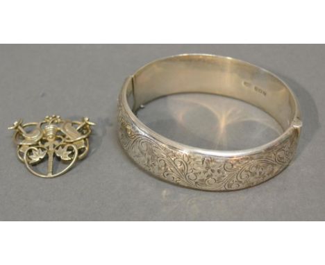 A Birmingham Silver Bangle with engraved decoration together with a white metal brooch with pierced decoration depicting two 