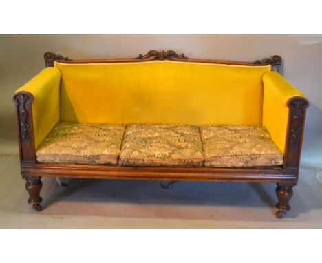 A William IV Mahogany Drawing Room Sofa with a scroll carved back and similar arms, raised upon turned legs, 155 cms wide 