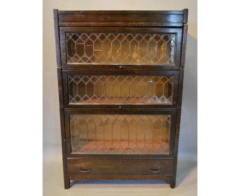 A Globe Wernicke Type Oak Sectional Bookcase, with three lead glazed doors above a drawer raised upon square legs, 89 cms wid
