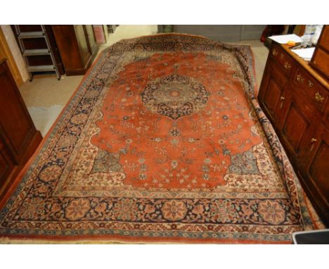 A North West Persian Style Woollen Carpet with a central medallion within an all over design upon a red, cream and terracotta