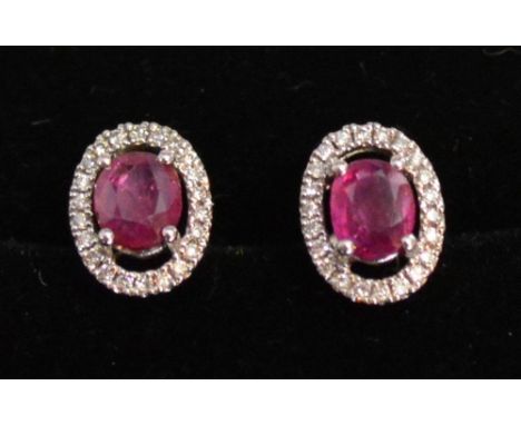 A Pair of 18ct. White Gold Ruby and Diamond Cluster Ear Studs, rubies approximately 0.95 ct, diamonds approximately 0.16 ct 