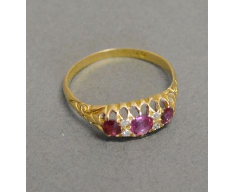 A 15ct. Yellow Gold Ruby and Diamond Band Ring set three rubies and four diamonds within a pierced setting 