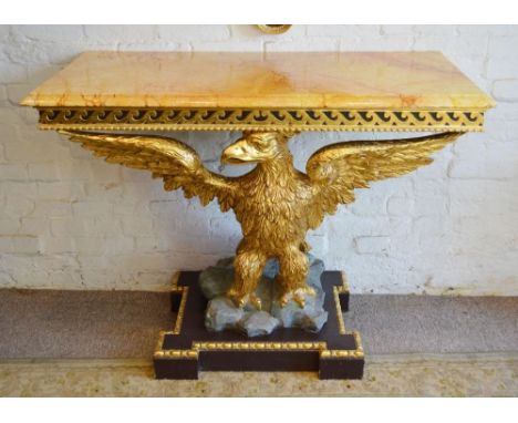 A Carved Giltwood Console Table, the simulated marble top above a relief scroll frieze, the support in the form of a large ca