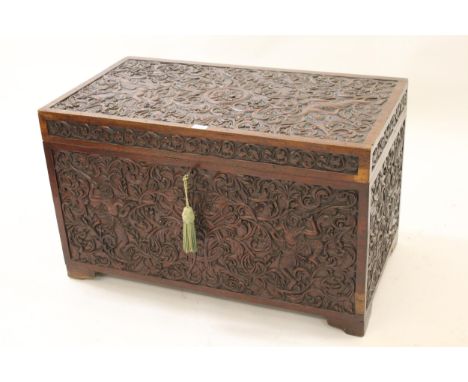 19th Century Indian walnut trunk, all over carved with figures in foliage, the hinged cover opening to reveal two further sma