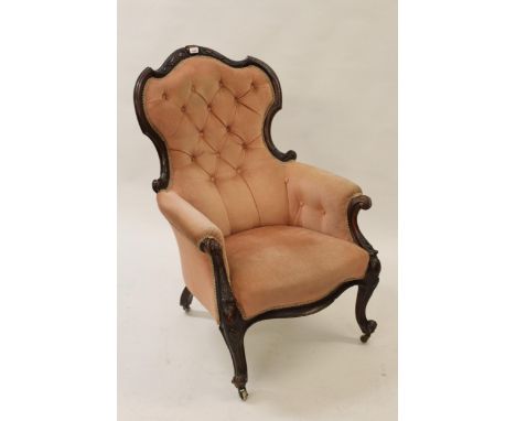 Victorian mahogany and button upholstered spoon back elbow chair, on carved cabriole front supports 