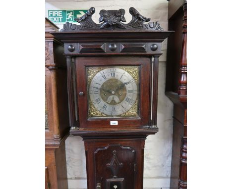 Unusual small oak longcase clock, the square hood with floral surmount and flanking pilasters above a shaped panel door and c