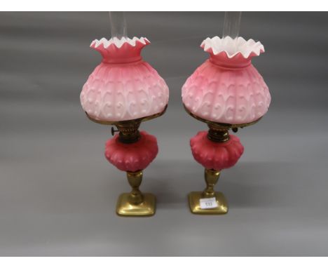 Pair of late 19th Century / early 20th Century pink opaque glass oil lamps, with matching shades and chimneys on brass candle