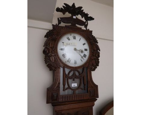 19th Century Continental oak longcase clock, the floral carved hood with a bar glazed pendulum window above a rectangular pan