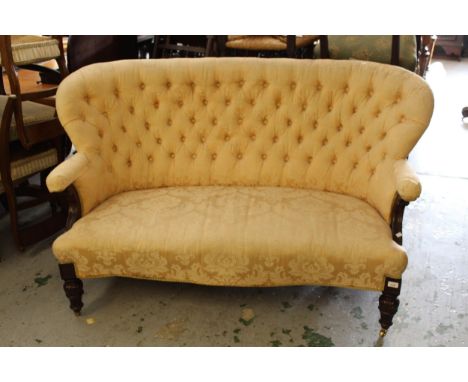 Early Victorian button upholstered two seat sofa, the shaped back and scroll arms above an overstuffed seat covered in figure