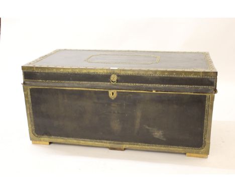 Large leather covered brass bound and studded trunk, with hinged cover and brass end handles, 42ins wide 