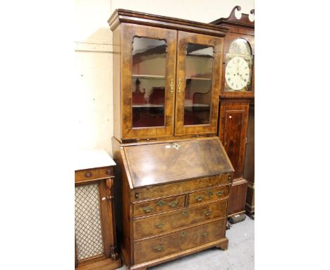 Walnut bureau bookcase, the moulded cornice above two shaped glazed panel doors enclosing shelves, the base with a fall front