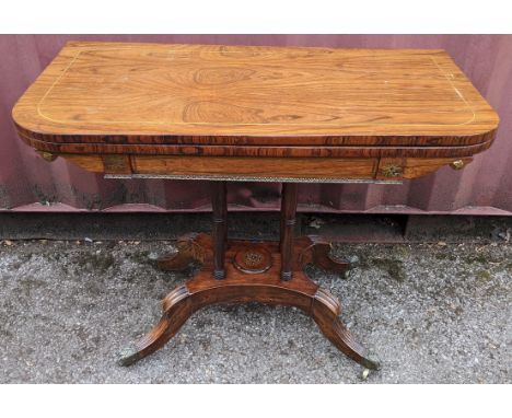 A Regency rosewood card table, having string inlaid top, green playing baize, gilt metal mounts and inlaid, raised on four tu