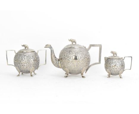 A late 19th/early 20th century Indian white metal three piece tea service, consisting of a teapot, sugar bowl and milk jug, e