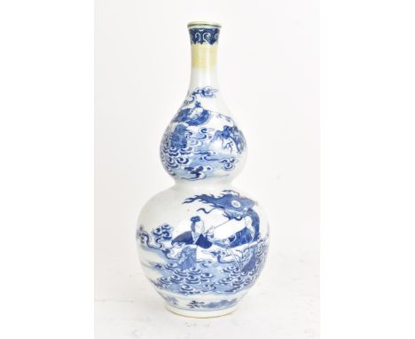 A Chinese Qing dynasty blue and white double gourd vase, late Kangxi/early Qianlong, decorated with scenes of figures among c