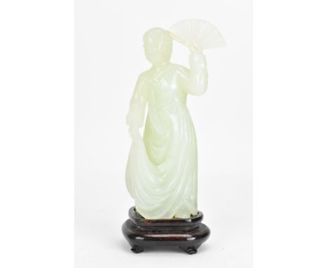 A 20th Chinese jade coloured sculpture of a Geisha figure in a dress, holding a fan aloft in her left hand, raised on a mould