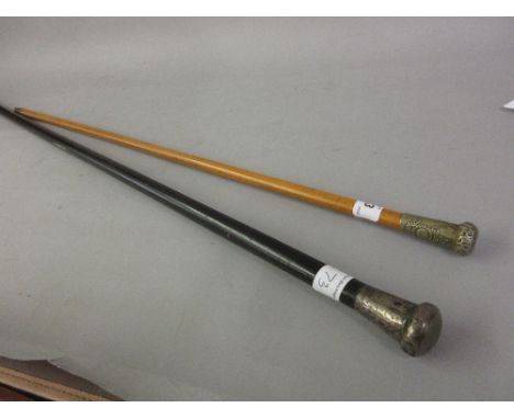 Military swagger stick and a silver mounted ebonised walking cane