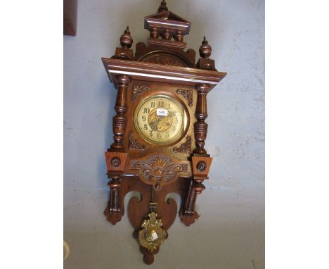 Late 19th Century American walnut cased wall clock of Art Nouveau design with an architectural pediment, a two train movement