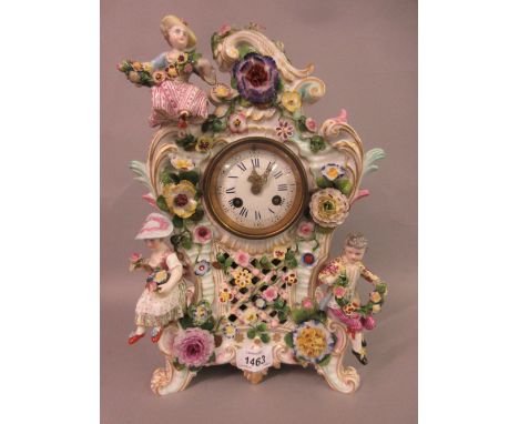 19th Century Continental porcelain figure and floral encrusted mantel clock, the shaped rococo design case with an enamel dia
