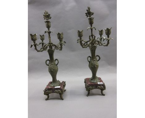 Pair of late 19th or early 20th Century French patinated spelter and rouge marble five light candelabra clock garnitures