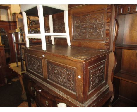 Late 19th Century carved oak monks bench, the fold-over top above a box seat base (at fault)