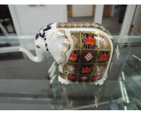 A Royal Crown Derby paperweight, Elephant with raised trunk, gilt stopper