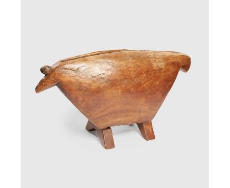 carved wood, standing on four rectangular legs, the body with a narrow aperture at the top and with finial lugs giving the im