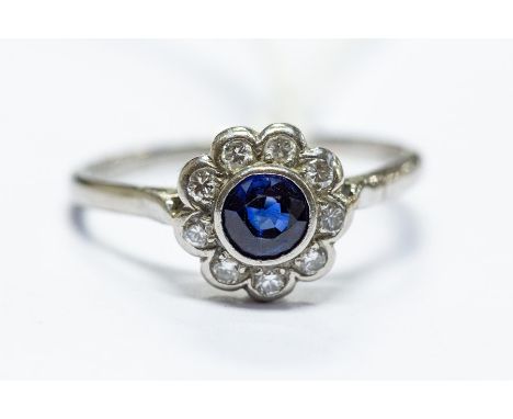 An Edwardian style 18ct white gold sapphire and diamond flowerhead ring, size O, 2.18 grams approx