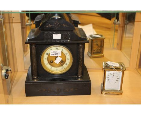 A late 19th Century black slate clock, together with a brass Edwardian carriage clock, complete with key. (2)