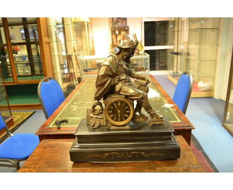 A bronzed mantle clock on black marble plinth