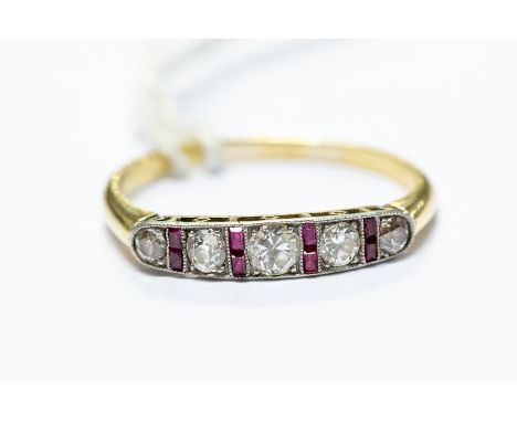 An Art Deco diamond and ruby set ring, old cut graduated round diamonds with alternate ruby set lines, mille grain edge, unma