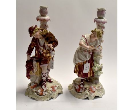 A pair of late 19th Century figurines, candlestick holders together with four Victorian Staffordshire figure groups, comprisi