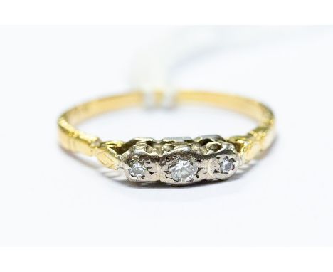 An 18ct gold three stone diamond illusion-set ring, platinum set, ring size O 1/2, 2.46 grams approx