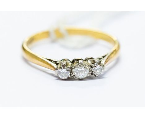 A three stone diamond ring, three round brilliant-cut diamonds approx 0.33ct total, platinum claw setting, 18ct yellow gold m