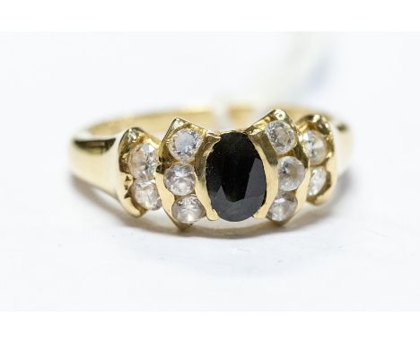 A 14ct gold dress ring, with central dark blue stone flanked by clear stones, size L, total gross weight approx 3.2gms