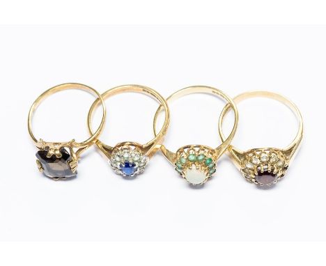 Four 9ct gold rings, set with garnet, smoky quartz, opal, emerald etc, total gross weight approx 9.5gms