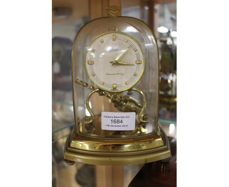 A mid-20th century mantle clock, raised on brass legs and complete with pendulum, Schatz, Germany tectronic, complete within 