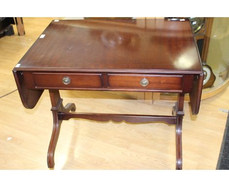 A Victorian mahogany sofa table, with two frieze drawers opposing, raised on trestle ends to scroll feet on brass castors uni