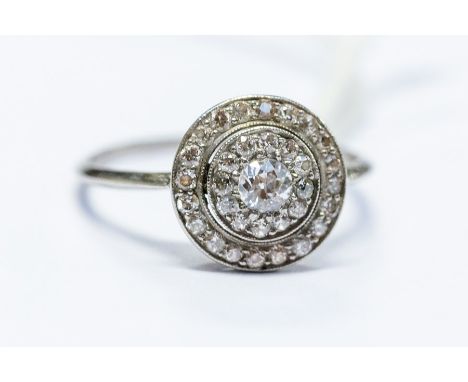 An Art Deco diamond cluster ring, round cluster setting, comprising a old cut diamond centre with double diamond set border o