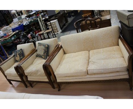 A 20th century mahogany framed two seater sofa, brass studs on arm rest, cream upholstered raised on squared supports; two ar