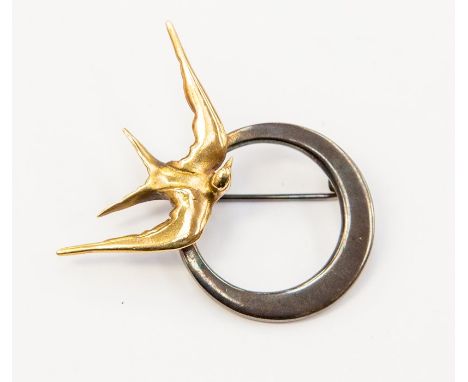 A silver and yellow metal "swallow" brooch, fashioned as a silver ring with offset centre and applied yellow metal swallow in