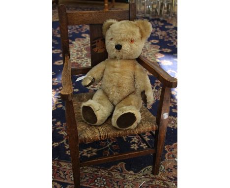 A Liberty style early 20th Century children's chair with straw seat with Chad Valley Teddy Bear, circa 1950/60's